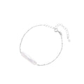 Minimalist bracelet with iridescent baroque pearl on rhodium-plated sterling silver chain against cream background