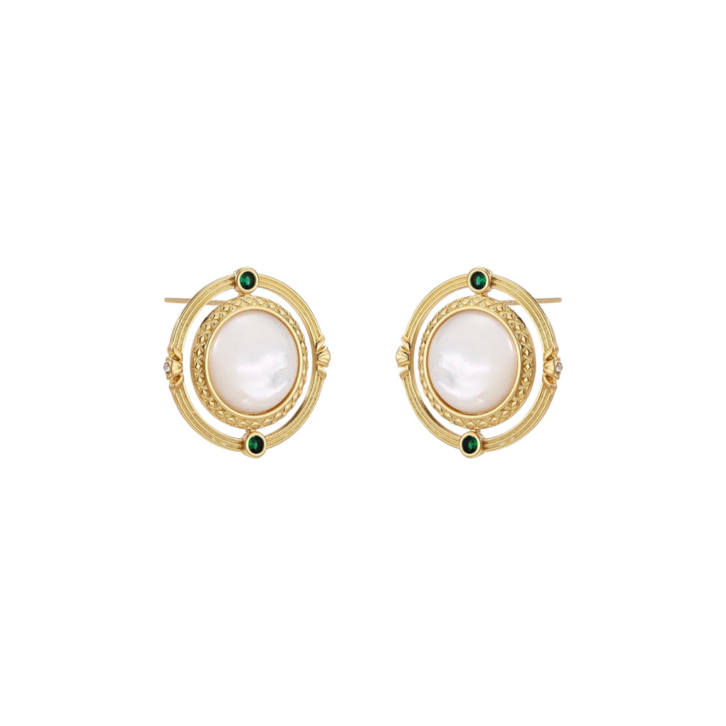 Circular gold stud earrings with iridescent mother-of-pearl center and green zirconia accents on cream background.