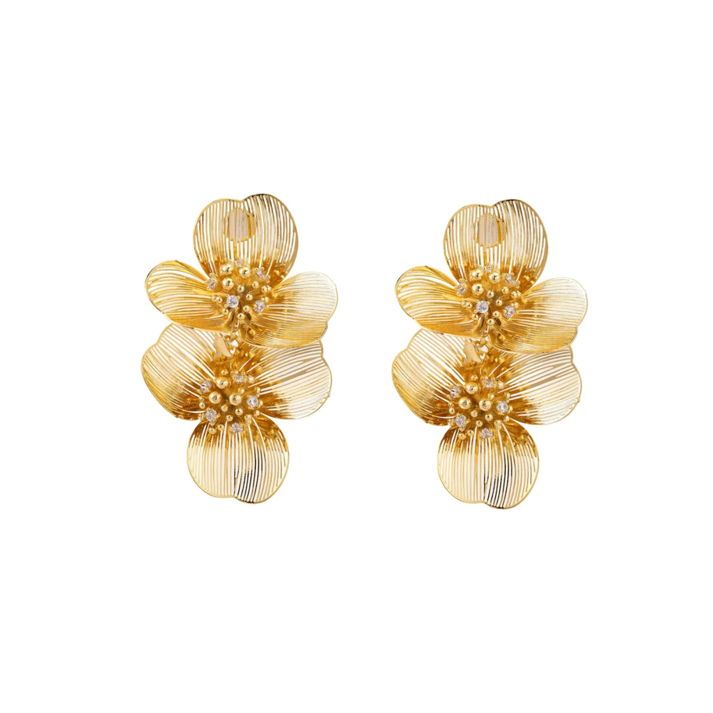 Pair of gold-plated double flower earrings with textured petals and crystal centers on cream background.