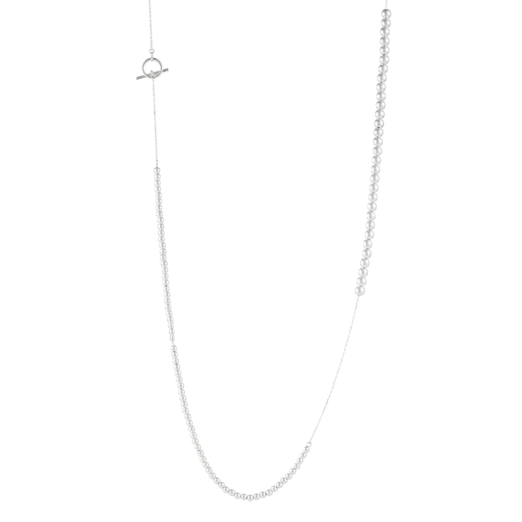Long sterling silver beaded necklace with graduated sphere design, toggle clasp, and delicate chain extension on white background