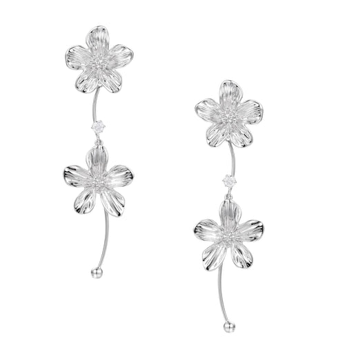 Silver-white asymmetric earrings with textured flower petals and crystal centers on cream background