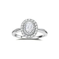 Sterling silver ring with oval moissanite center stone surrounded by double halo of sparkling stones on neutral background.