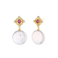 Gold baroque pearl earrings with pink gemstone studs and ornate detailing on cream background.