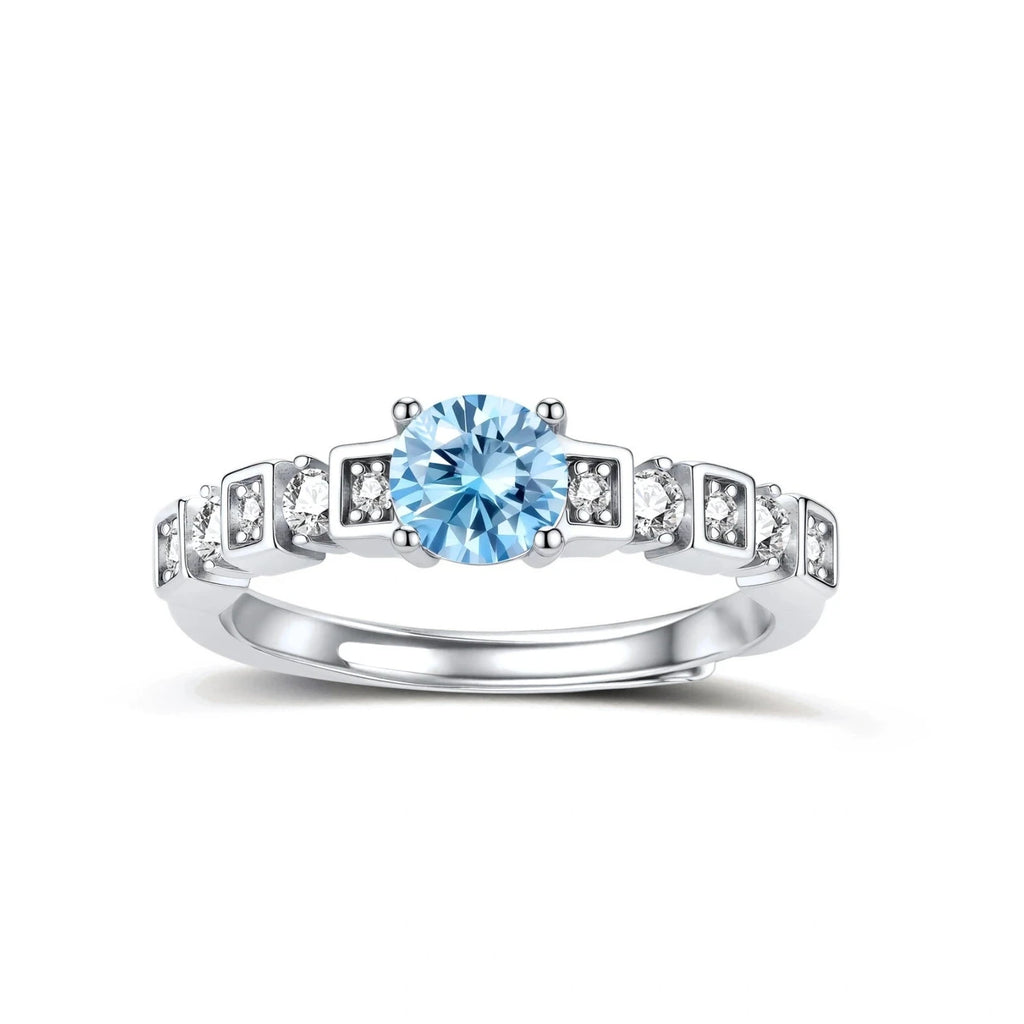 Geometric sterling silver ring with light blue moissanite center stone and square diamond accents on white background