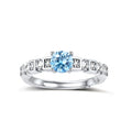 Geometric sterling silver ring with light blue moissanite center stone and square diamond accents on white background