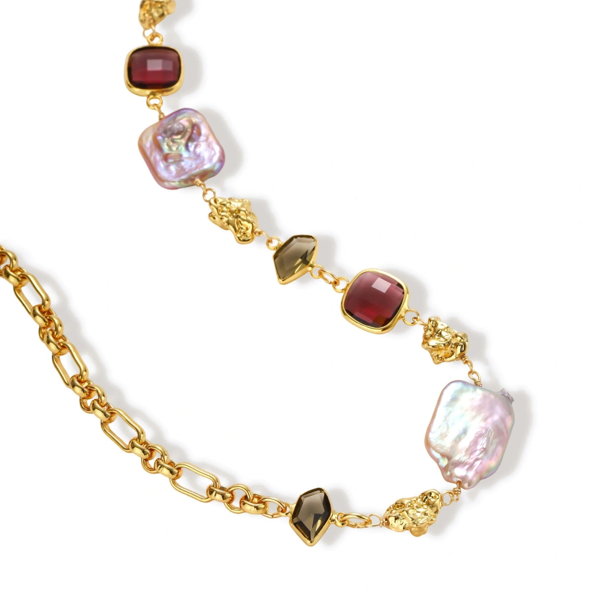 18k gold-plated chain necklace with iridescent baroque pearls and burgundy gemstones on white background.